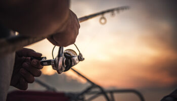 fishing,rod,wheel,closeup,,man,fishing,with,a,beautiful,sunrise